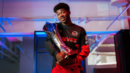 Lil Nas X in a 100 Thieves jersey holding the LCS Championship trophy