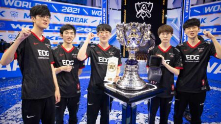Worlds 2021 champions Edward Gaming posing with the Summoner's Cup on stage