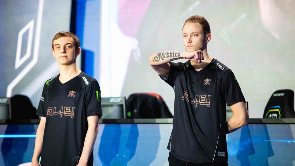 Rekkles mostrando su tatuaje de Rekkles en Worlds 2018 junto a Caps en el escenario