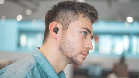 Man wearing Bluetooth earbuds by Harry Cunningham