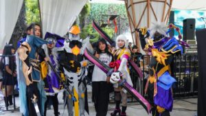 Mobile Legends cosplayers posing with a fan during the Nepal Otaku Jatra Comic Con, an event featuring one of the community MLBB tournaments.