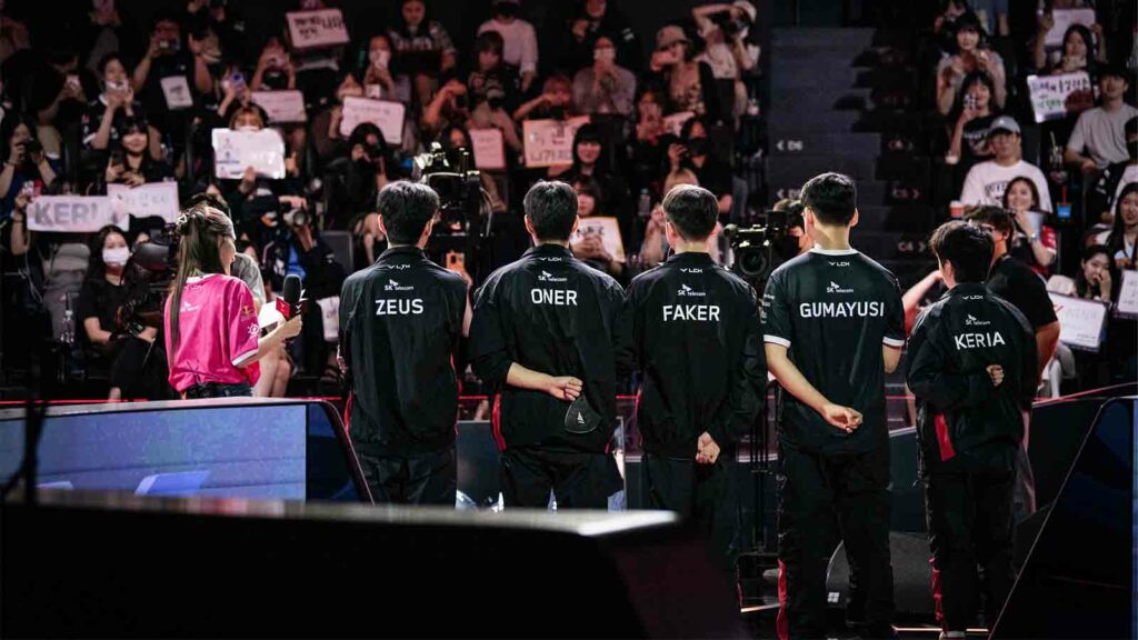 T1 on stage with their backs to the camera after winning round one of LCK Summer 2023 playoffs